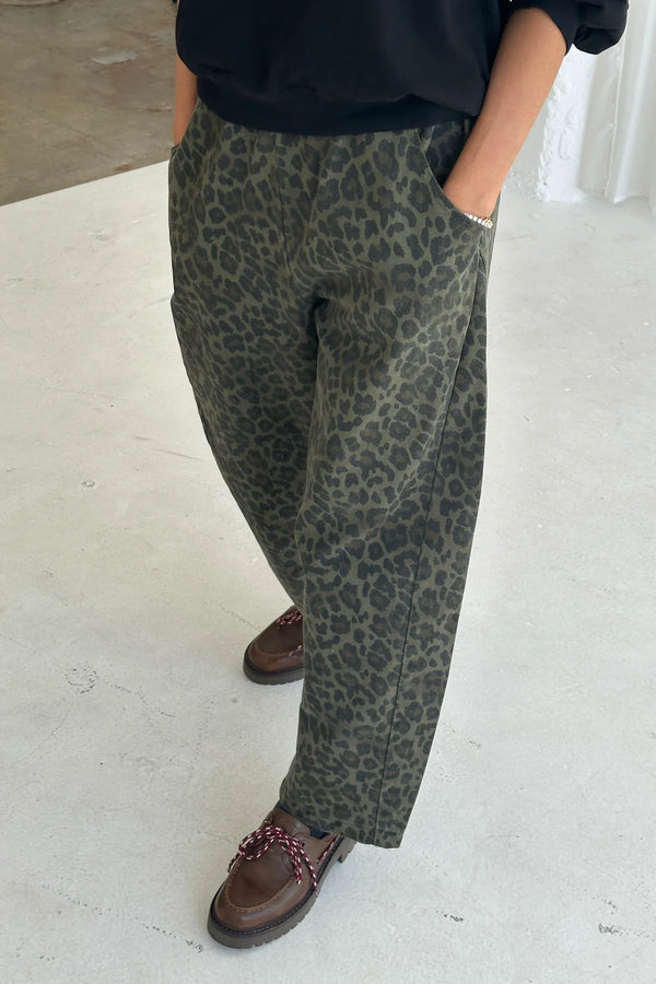 Sylwetka w spodniach Le Bon Shoppe Arc Pants Fern Leopard z dłońmi w kieszeniach.