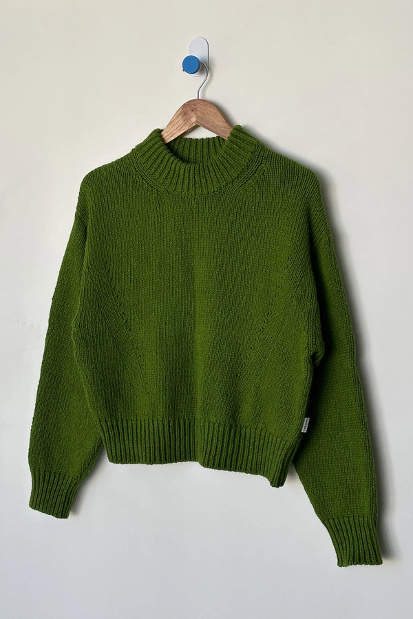 Zielony sweter bawełniany Le Bon Shoppe Zoe Avocado zawieszony na wieszaku.