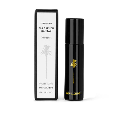 Czarna butelka perfum w olejku Blackened Santal marki RAAW Alchemy obok dedykowanego białego opakowania kartonowego.
