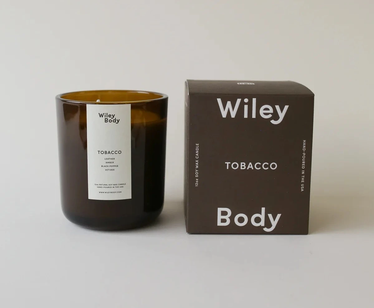 Wiley Body – Bestsellerowa świeca sojowa Tobacco w bursztynowym słoiku z litnym knotem oraz kartonowe opakowanie prezentacyjne z logiem marki na jasnym tle.
