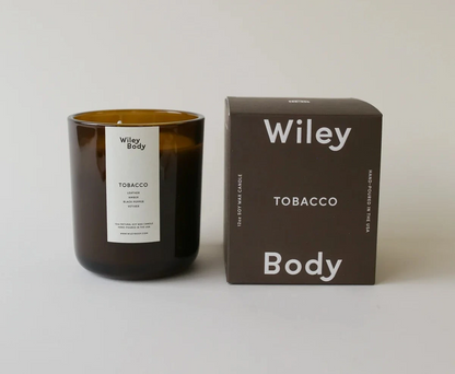 Wiley Body – Bestsellerowa świeca sojowa Tobacco w bursztynowym słoiku z litnym knotem oraz kartonowe opakowanie prezentacyjne z logiem marki na jasnym tle.